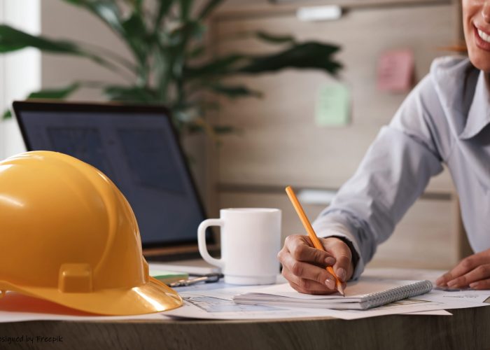 female architect taking notes while working on new plans in the office.